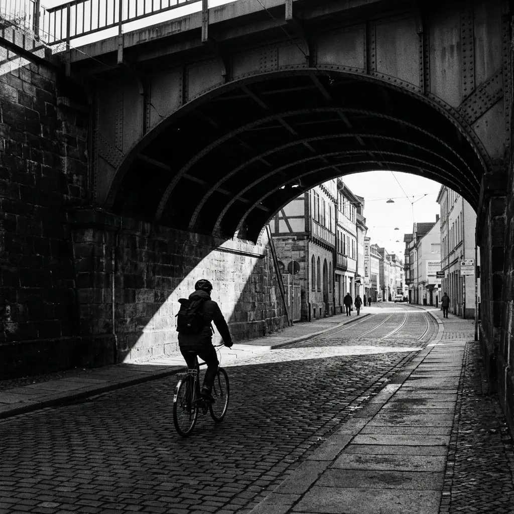 Platzhalterbild: Schwarz-Weiß-Foto, Radfahrer unter einer alten Eisenbahnbrücke